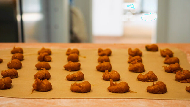 Rows of freshly made tortelli dough are neatly arranged on parchment paper, ready for the next step in the cooking process