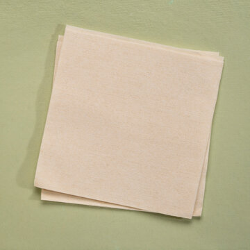 blank cocktail napkin against textures art paper