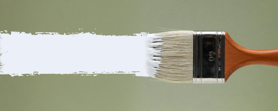 Paint Brush Applying Horizontal White Paint Stroke over Green Background with Copy Space