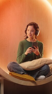 Carefree young Asian woman listens to favorite music in headset, leisure time