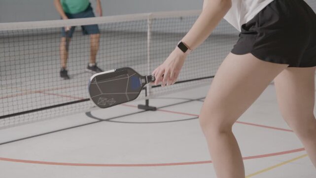 Pickleball players in a modern school gym co-ed practicing and having fun