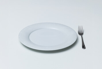 Fototapeta premium Empty Ceramic Plate with Silver Fork on White Background
