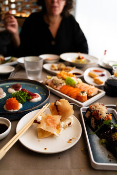 Woman dining at table with assorted Asian dishes