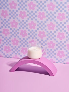 Aesthetic milk in a glass mug rests on a pink arch