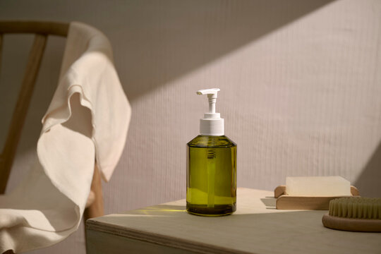 Minimalist bathroom scene with green liquid soap dispenser