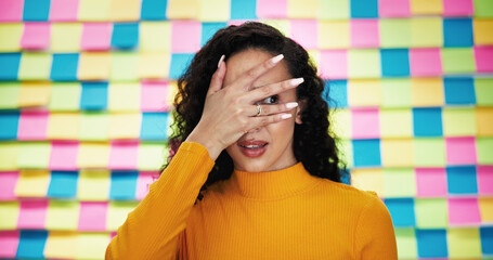 Scared, woman and face with colorful background for horror, rumor or nervous expression in studio....