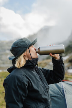 A hiker drinking water from a bottle