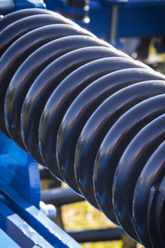 Steel black spring as part of heavy agricultural, industrial machine. Technology