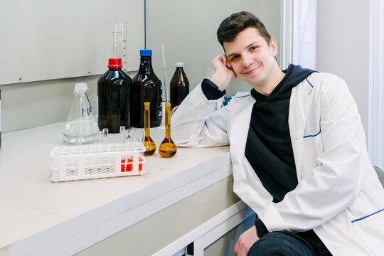 A chemist is sitting in a laboratory with samples and equipment.