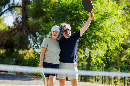 Senior couple enjoying active pickleball game celebrating vitality