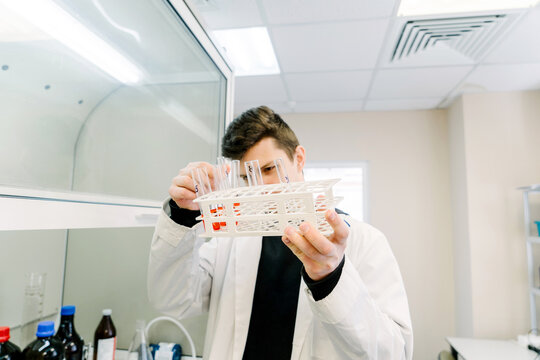 A man holds test tubes in a laboratory.