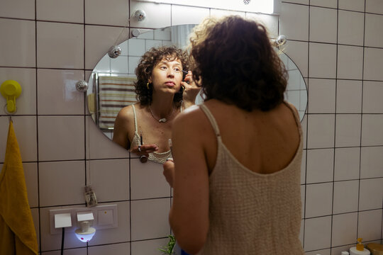 woman doing makeup at home