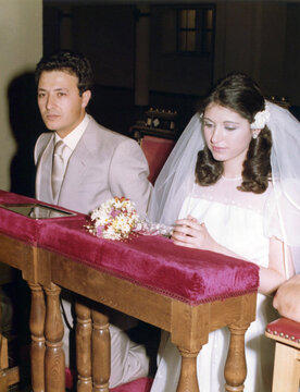 Bride and groom kneeling during religious wedding ceremony