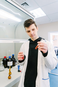 A chemist studies test tubes in a chemical laboratory.