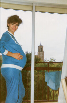 Pregnant woman smiling feeling her baby bump