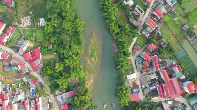Aerial drone footage of That Khe town in Lang Son province, Vietnam, showing a small urban area with colorful rooftops, a winding river, and surrounding green farmland.