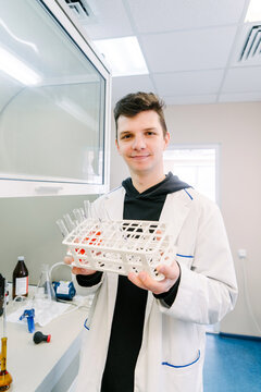 A chemist holds test tubes in his hands.