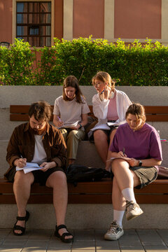 Group of students studying together on outdoor bench