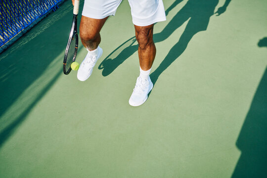 Tennis player picking up a tennis ball