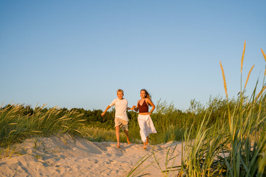 Brother and Sister Running in the Beach