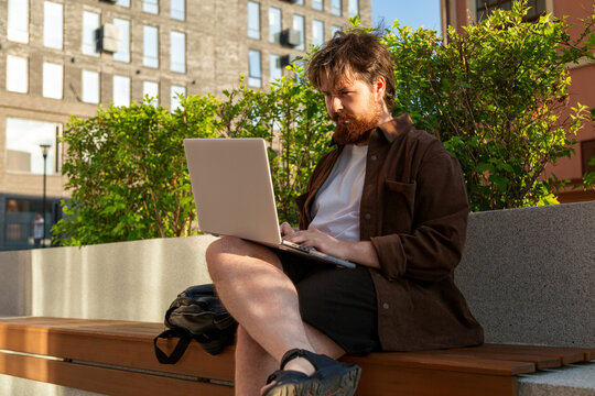 Student using laptop outdoors on rooftop terrace