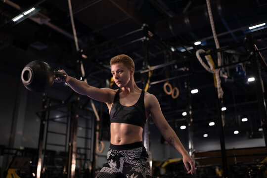 Strong sportswoman exercising with kettlebell