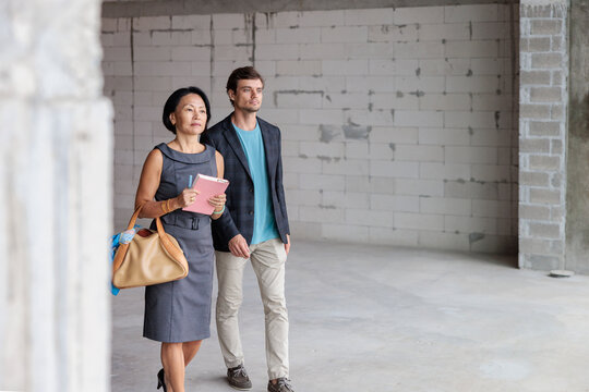 Business professionals inspect an unfinished construction site
