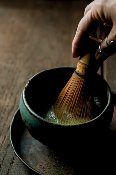 Hand whisking matcha in a tea bowl