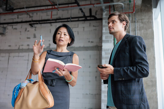 Architect and client discussing plans at a construction site.