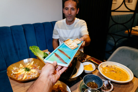 Man sharing anchovy appetizers at a fine dining restaurant