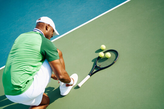 Tennis player tying shoe on court