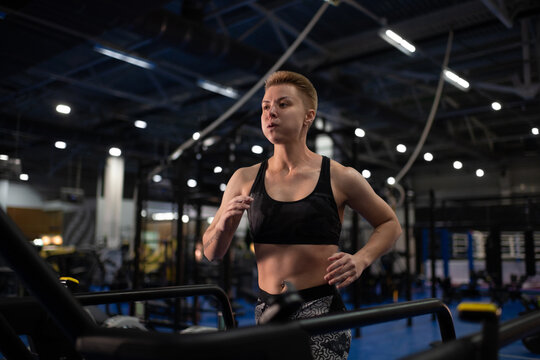 Exhausted sportswoman running on treadmill