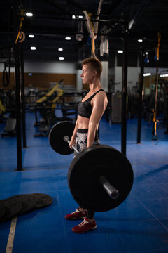 Powerful sportswoman doing deadlift exercise in gym