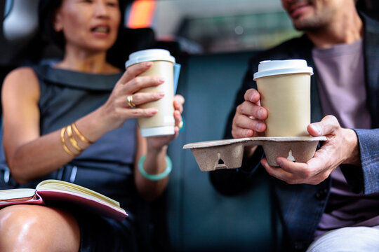 Business partners sharing coffee during their commute