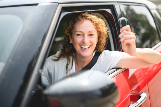 shot of smiling mature woman driving her car in the city.