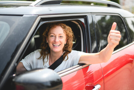 shot of smiling mature woman driving her car in the city.
