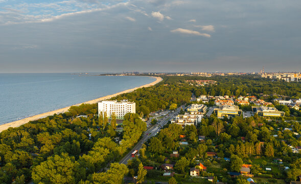 Aerial view of the sandy beach, lush forest, and coastal architecture along the Baltic Sea in Sopot, Pomeranian Voivodeship, Poland.