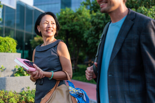 Professional colleagues walking and conversing outdoors
