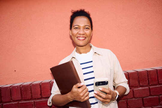 Portrait of a businesswoman smiles in front of the wall