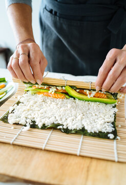 chef Rolling maki sushi on a bamboo mat