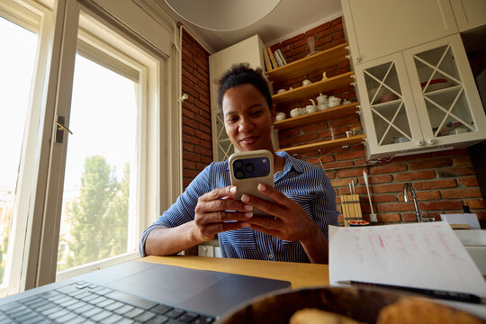 Woman works from home, checking her phone