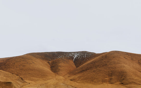 Patchy Snow and Wind-Eroded Textures on High-Altitude Slopes.