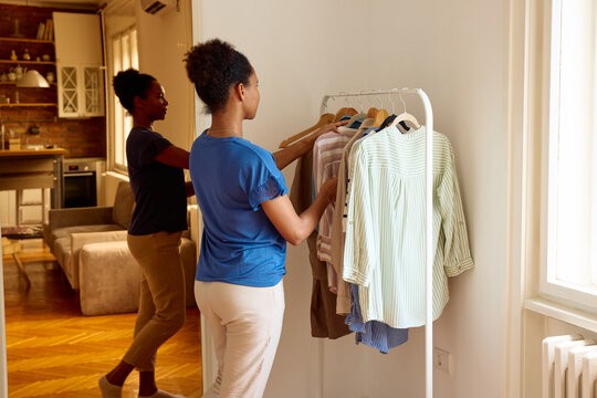 Woman is choosing clothes from a hanger