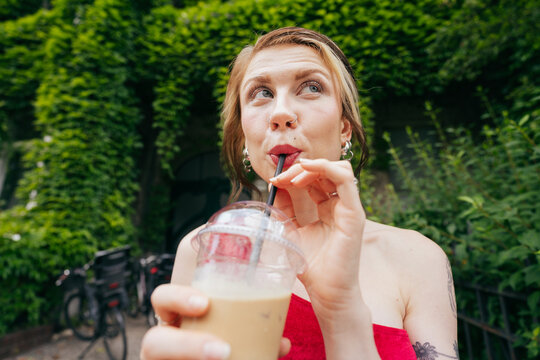 Woman Sipping Iced Drink Outdoors