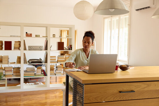 Woman works from home, taking notes