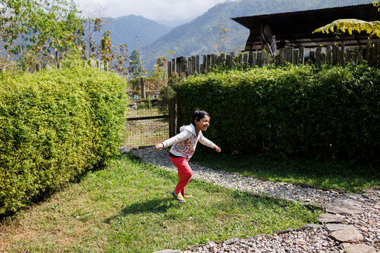 Child Plays and runs in Green Garden on Sunny Day