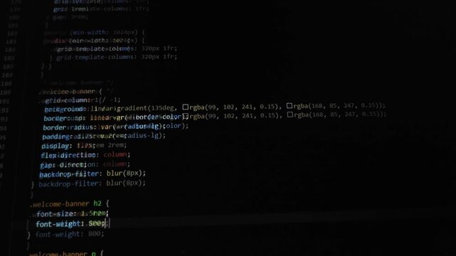 Source code scrolling on computer screen in dark theme editor