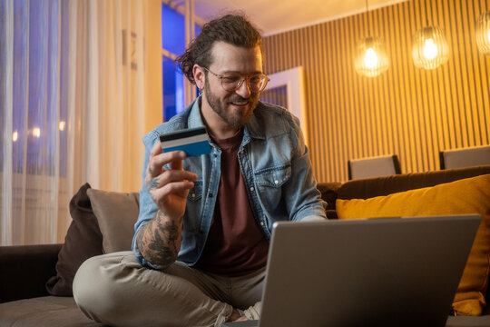 Man, credit card and happy with laptop in home for online shopping, cart checkout and rewards voucher code. Fintech, person or internet portal for bills payment, banking or debit pin for subscription
