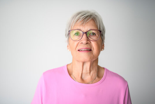 Portrait of elderly woman with eyeglasses over studio white