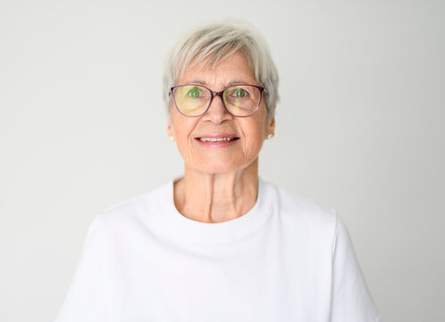 Portrait of elderly woman with eyeglasses over studio white